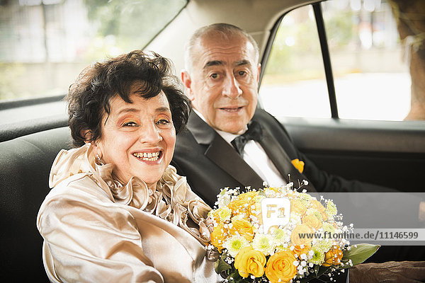 Älteres frisch verheiratetes Paar fährt im Auto