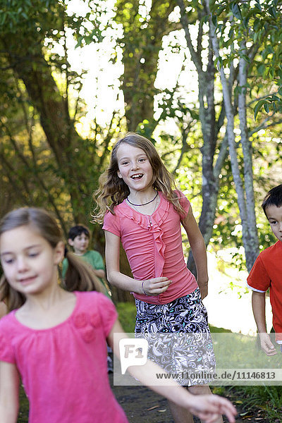 Kinder laufen auf einem Feldweg im Park