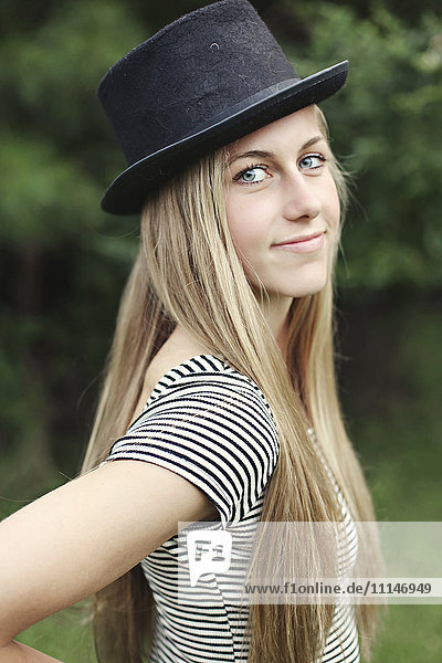 Smiling woman wearing top hat outdoors