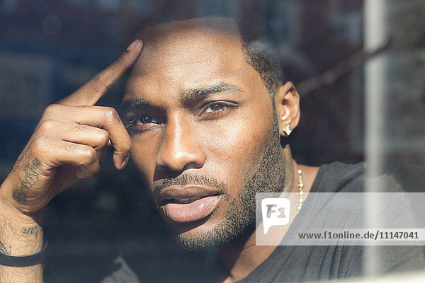African American man looking out window