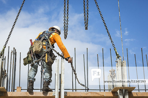 Caucasian worker holding chain at construction site