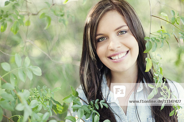 Close up of smiling woman standing in garden