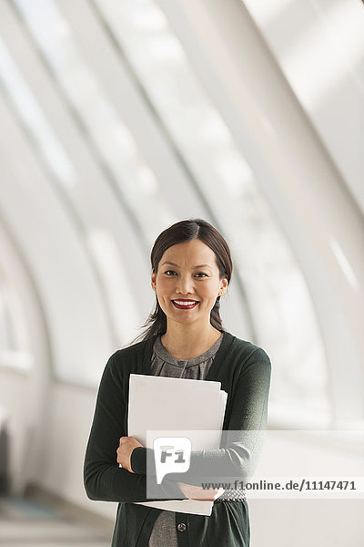 Japanische Geschäftsfrau mit Papieren in der Lobby