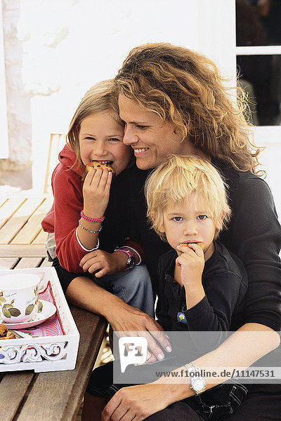 Caucasian mother and children eating outdoors