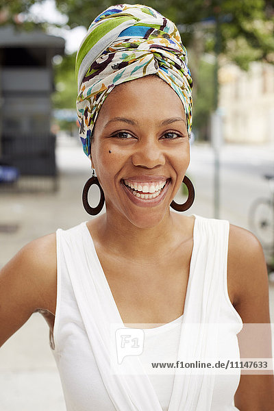 Schwarze Frau lächelnd auf einer Straße in der Stadt