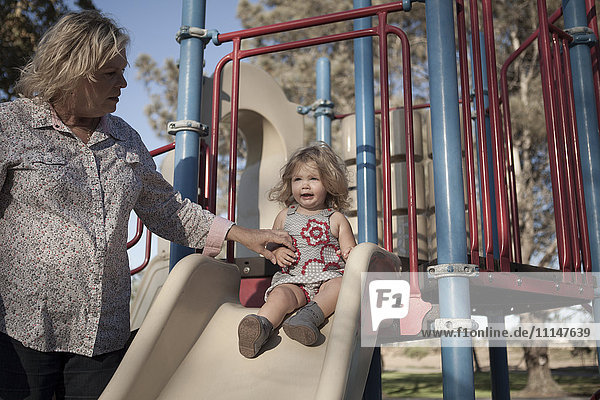 Grandmother and granddaughter playing at playground