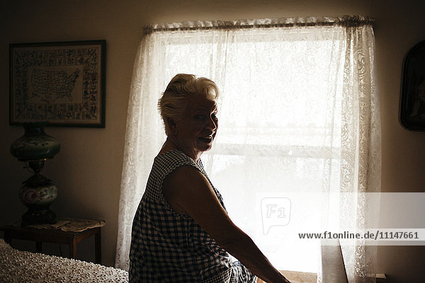 Smiling older woman sitting on bed