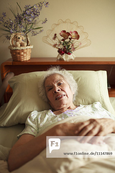 Ältere Frau gemischter Rasse liegt im Bett