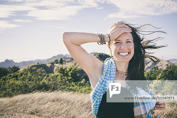 Lachende kaukasische Frau auf einem ländlichen Feld