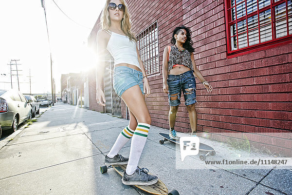 Women riding skateboards on city street