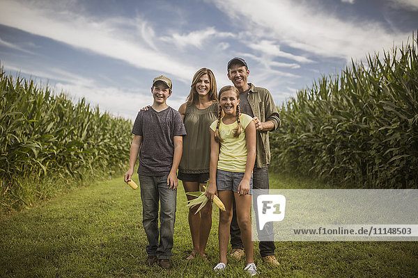 Caucasian family smiling in corn field