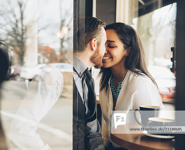 Lächelndes Paar  das sich im Café küsst