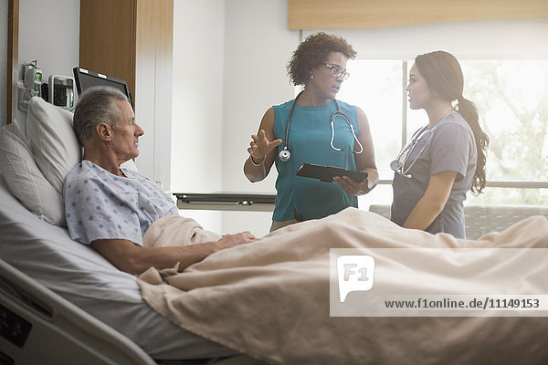 Doctor and nurse with patient in hospital room