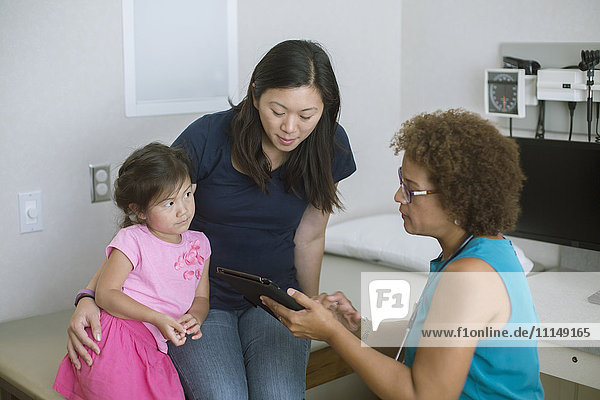 Doctor using digital tablet with patients