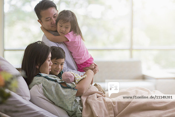Familie bewundert neugeborenes Baby im Krankenhauszimmer