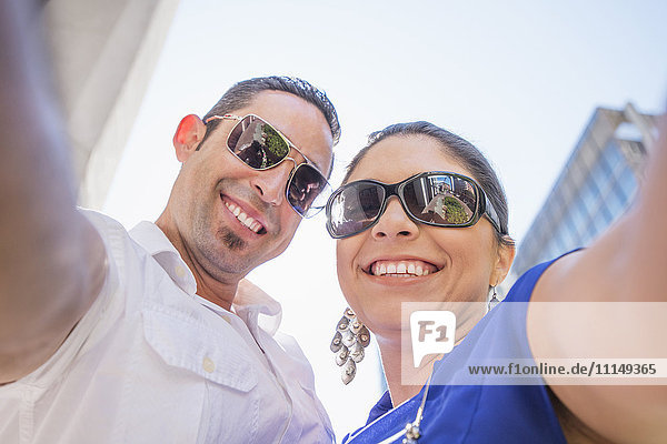 Niedriger Blickwinkel auf ein hispanisches Paar mit Sonnenbrille