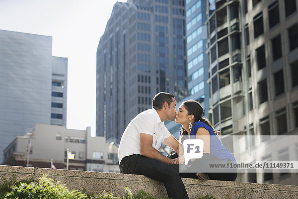 Hispanisches Paar küsst sich in der Stadt
