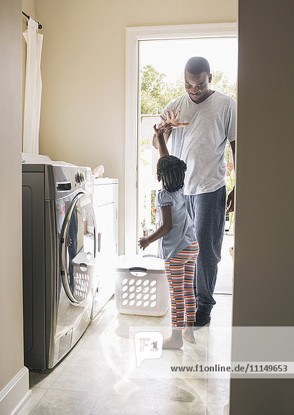 Afroamerikanischer Vater und Tochter beim Wäschewaschen