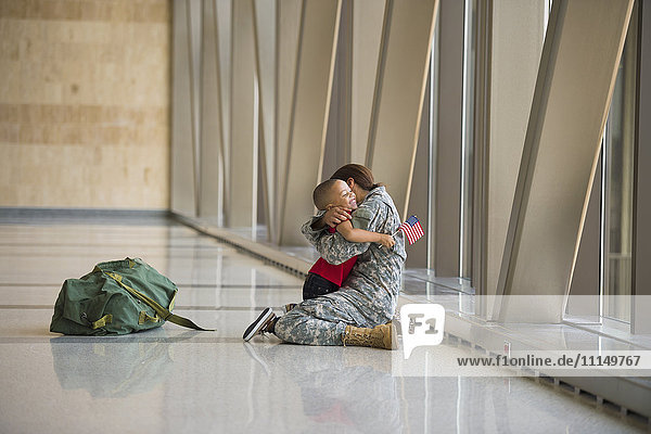 Afroamerikanischer Soldat umarmt seinen Sohn am Flughafen