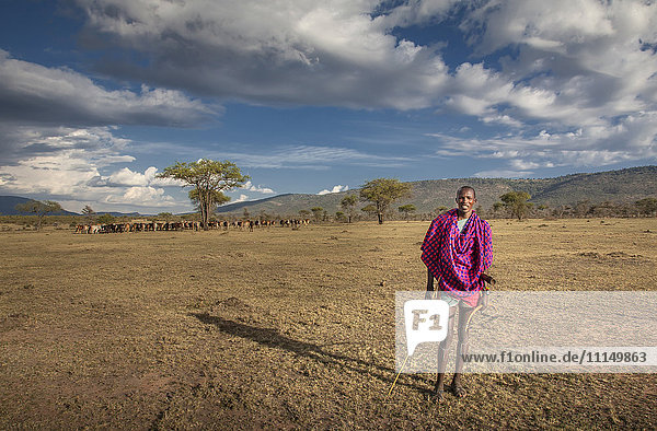 Black man in traditional clothing standing in remote field