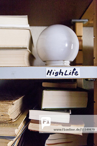 Nahaufnahme einer Glühbirne auf einem Regal mit Büchern