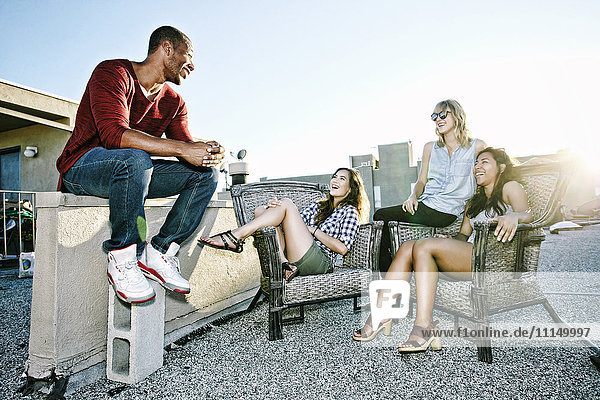 Friends relaxing on urban rooftop