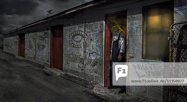 Man standing in dilapidated building doorway
