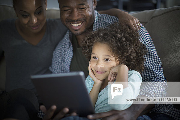Familie benutzt digitales Tablet auf dem Sofa