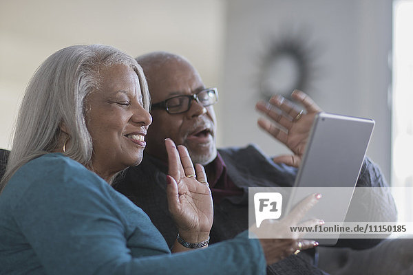 Older couple video chatting with digital tablet