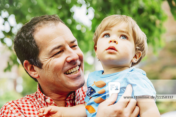 Father holding baby son outdoors