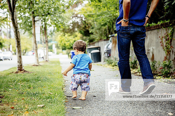 Vater und kleiner Sohn gehen im Freien spazieren
