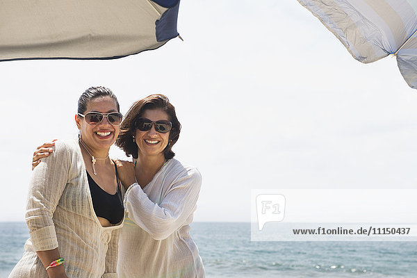Hispanische Frauen lächeln gemeinsam am Strand