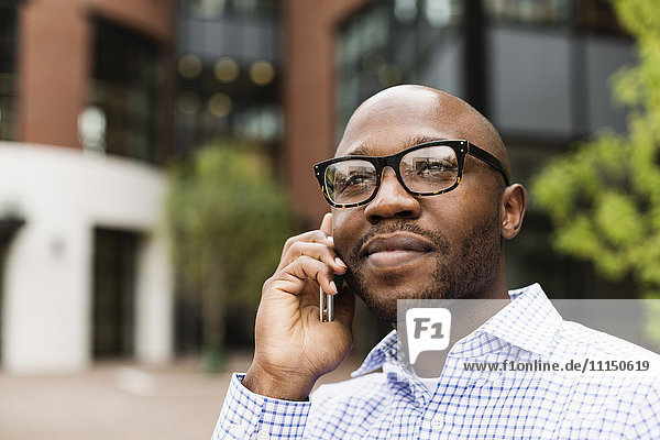 Schwarzer Mann telefoniert mit Handy in der Stadt