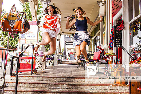 Kaukasische Teenager-Mädchen springen vor Freude in der Stadt