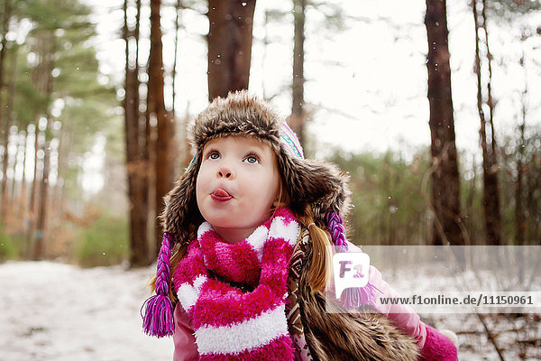 Kaukasisches Mädchen fängt Schnee auf der Zunge