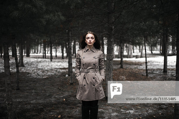 Kaukasische Frau steht im verschneiten Wald
