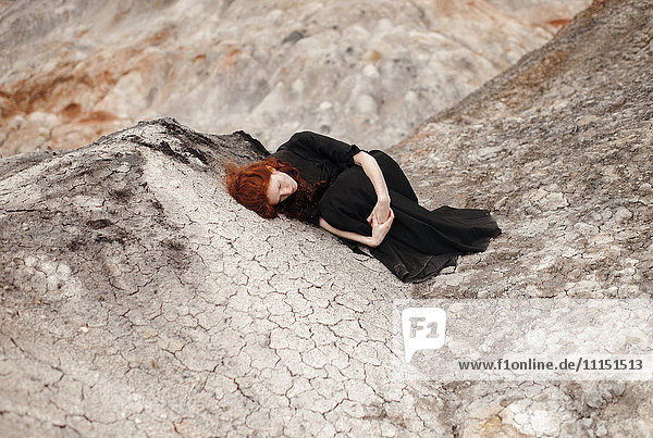 Caucasian woman laying on rock formation