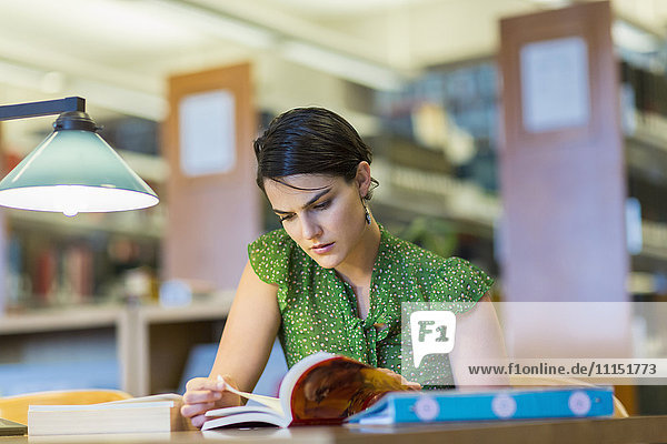Gemischtrassiger Student studiert in der Bibliothek