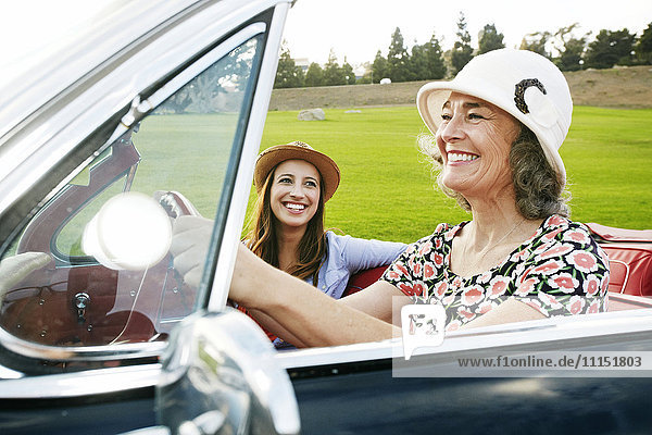 Mutter und Tochter fahren in einem klassischen Cabrio