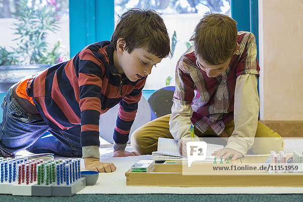 Kaukasische Jungen arbeiten im Klassenzimmer zusammen