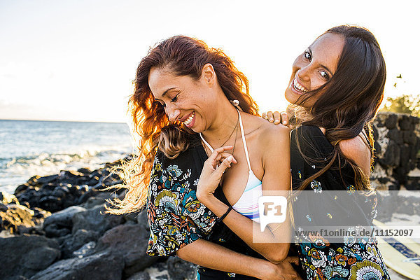 Women laughing on rocky beach