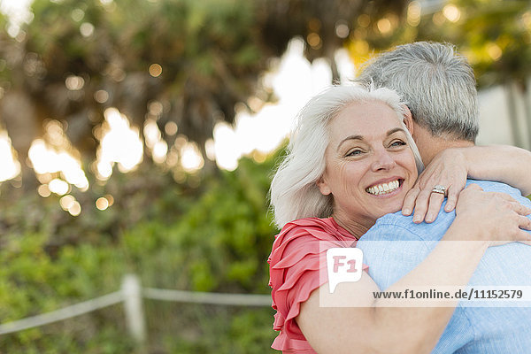 Close up of older Caucasian couple hugging