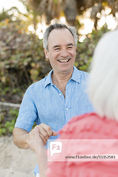Close up of older Caucasian couple talking on beach