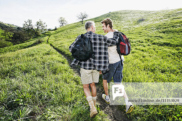 Caucasian father and son walking on dirt path