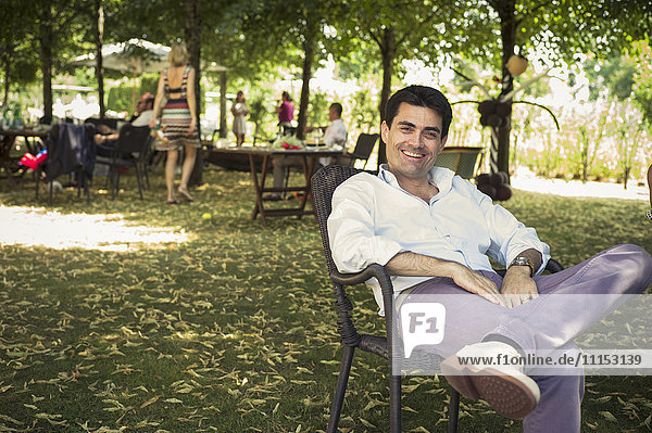 Caucasian man sitting in chair in backyard