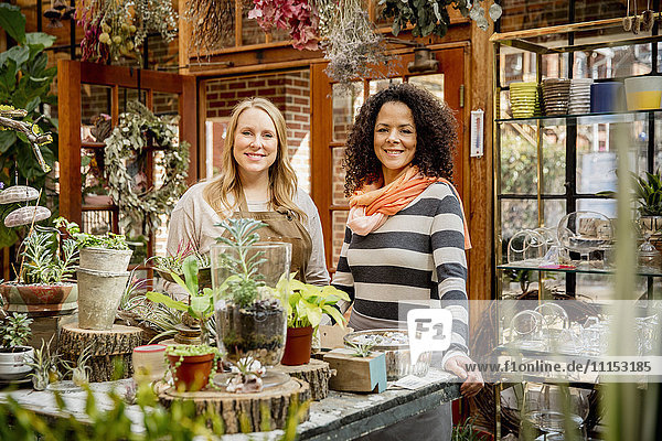 Employee and customer smiling in plant nursery