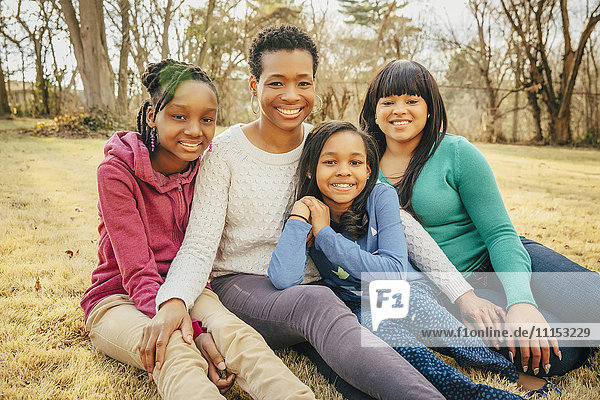 Black mother and daughters sitting outdoors