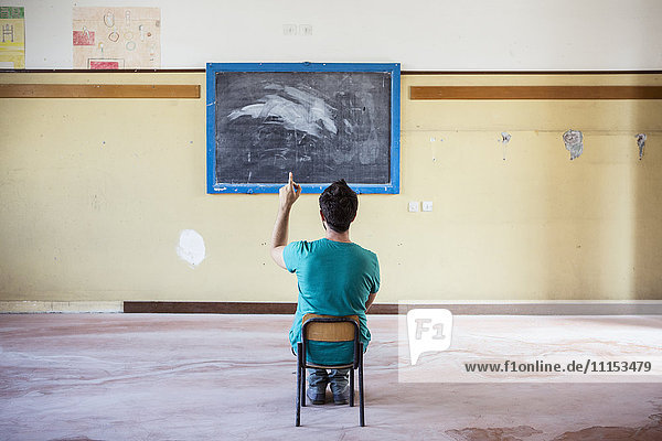 Kaukasischer Schüler sitzt in einem leeren Klassenzimmer