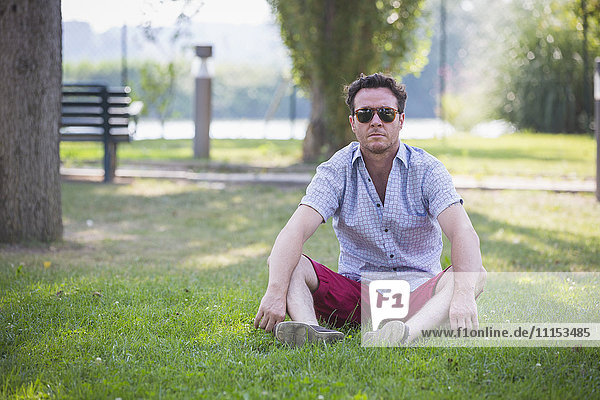 Caucasian man sitting in grass in park