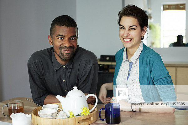 Couple smiling with tea at table